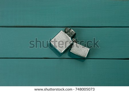 Gasoline lighter , metal lighter on a blue wooden background