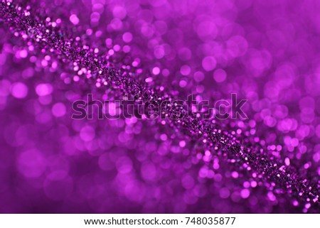 Abstract background of purple glittering defocused lights.