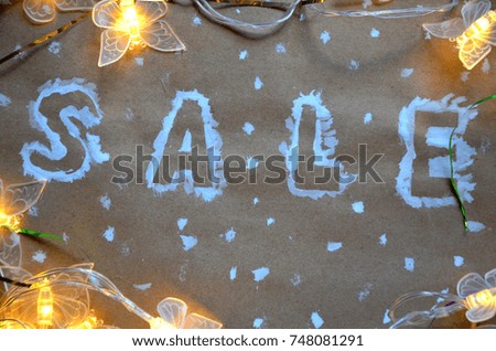 An inscription of a sale on a Christmas background. new year decoration. on kraft paper. Christmas boxes in snow with sale tag. christmas tree