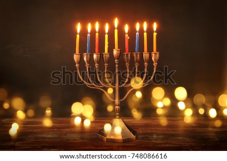 image of jewish holiday Hanukkah background with menorah (traditional candelabra) and burning candles. glitter overlay