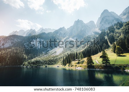 Scenic image of great alpine lake Vorderer Gosausee. Salzkammergut is a famous resort area located in the Gosau Valley in Upper Austria. Dachstein glacier. Explore the beauty of earth. Vintage tone.
