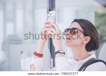 girl in sunglasses takes photo in museum closeup