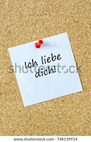 White paper on a pin board with the german words "I love you"
