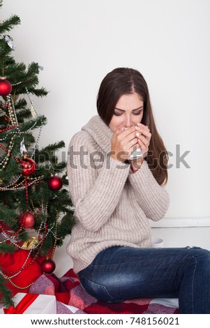 girl drinking coffee under the Christmas tree new year tea