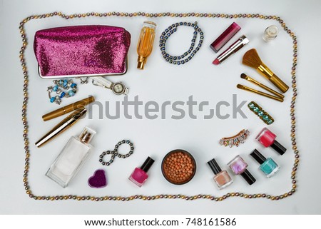 cosmetics, jewelry, perfumes and a beautiful pink cosmetic bag on a white background, top view