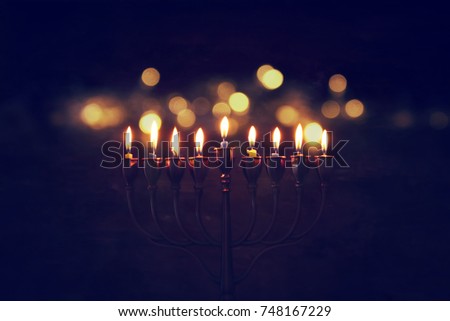Low key image of jewish holiday Hanukkah background with menorah (traditional candelabra) and burning candles. Royalty-Free Stock Photo #748167229