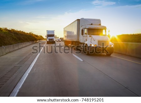 Old semi truck on road with sun flare Royalty-Free Stock Photo #748195201