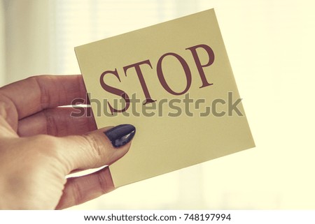 Female Hand Holding Paper with stop Letter