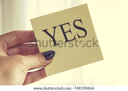 Female Hand Holding Paper with Yes Letter