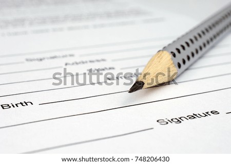 gray pencil laying over a contract waiting to be signed