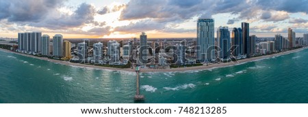 Aerial image of a beautiful sunset behind Sunny Isles Beach fishing pier and beachfront condos and hotels
