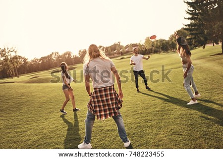 Having fun with friends. Full length of young people in casual wear playing while spending carefree time outdoors