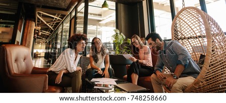 Business team working on new project and smiling. Man and women sitting together in modern office for project discussion. Royalty-Free Stock Photo #748258660