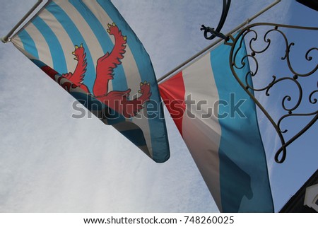 The flag of Luxembourg and the civil ensign flag of Luxembourg, viewed from below, in Luxembourg City Royalty-Free Stock Photo #748260025