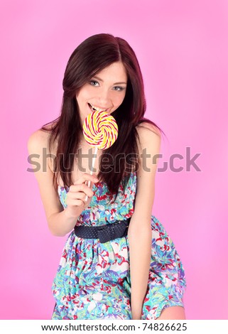 portrait of glamorous girl wearing colorful dress with lollipop