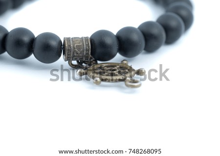 Black bracelet attached with rusty gold navy emblem isolated on white background