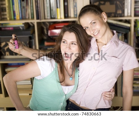 stock-photo-happy-young-girls-making-funny-face-while-taking-pictures-of-themselves-through-cellphone-