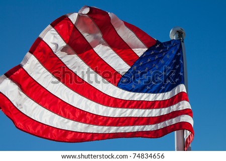 flying American backlight flag with copyspace against a blue sky