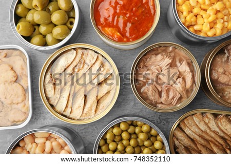 Open tin cans with different food on table Royalty-Free Stock Photo #748352110