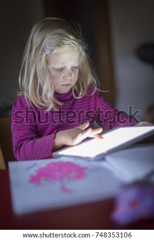 Portrait of cute blonde girl holding tablet