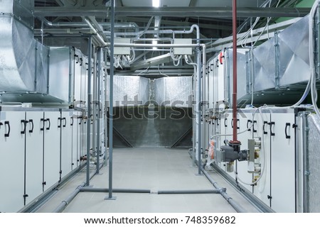 Two gray industrial air handling units in the ventilation plant room Royalty-Free Stock Photo #748359682