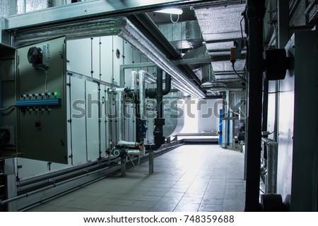 Side view of the huge industrial air handling unit in the ventilation plant room Royalty-Free Stock Photo #748359688