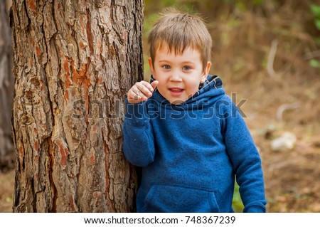 Happy cute Caucasian child with blue eyes in the forest. Happy childhood stock image. 