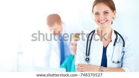 Attractive female doctor in front of medical group Royalty-Free Stock Photo #748370527