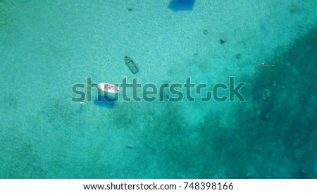 Aerial bird's eye view of boat taken by drone of tropical seascape with turquoise clear waters