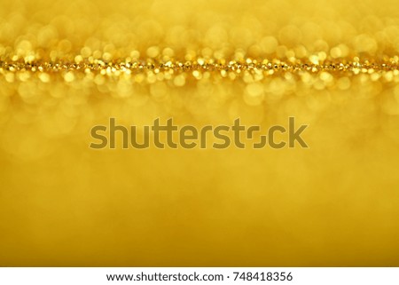 Abstract background of golden glittering defocused lights.