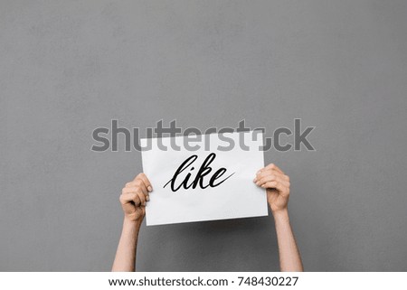 Close up photo of woman hands up that holding postcard on gray background