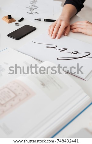 Close up photo of young woman hands with beautiful notes and open book on desk isolated