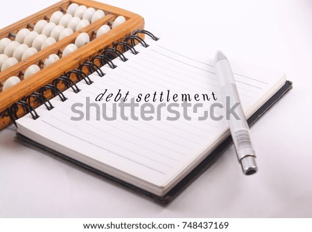 Conceptual photo for calculating debt, profit using abacus the traditional system in math.
with text debt settlement on note book.