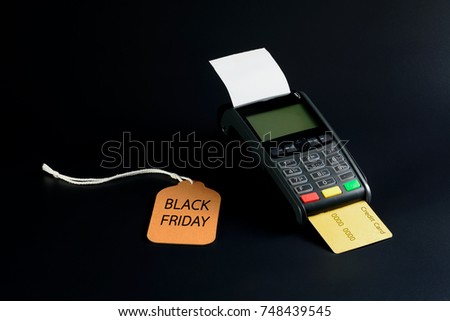 Price tag and credit card machine on black table background, Black Friday concept.