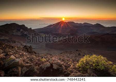 Starburst sunrise shot on the summit of Haleakala Volcano overlooking the volcanic crater  in Haleakala National Park on Maui in Hawaii Royalty-Free Stock Photo #748443241