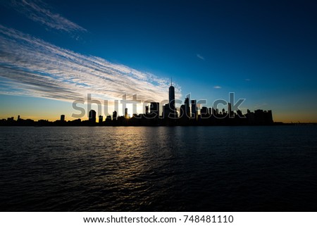 New York City Skyline at sunrise with a silhouette  that is rarely seen taken with a long exposure with all the tall buildings including the world trade center and the Hudson river at dusk til dawn