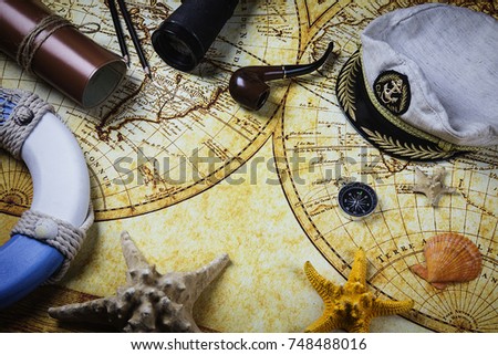 The hat of the captain on the sea chart. Compass seashells, starfish, binoculars. A journey in distant countries. Treasure island