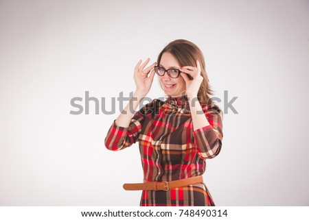 Happy beautiful young business woman standing and touching glasses over grey background