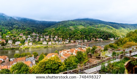 Europe culture concept - panoramic city skyline birds eye aerial view under dramatic sun and morning blue cloudy sky in Heidelberg, Germany
