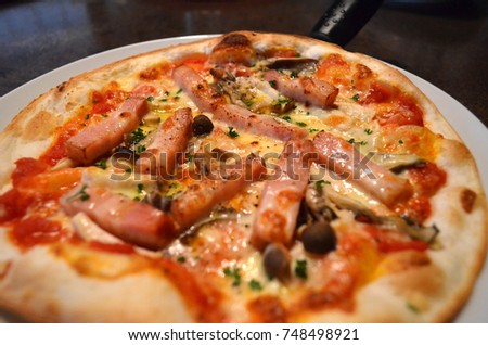 Italian tomato sauce pizza with bacon and mushrooms