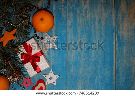 beautiful Christmas background with fir twigs and gift on blue wooden boards