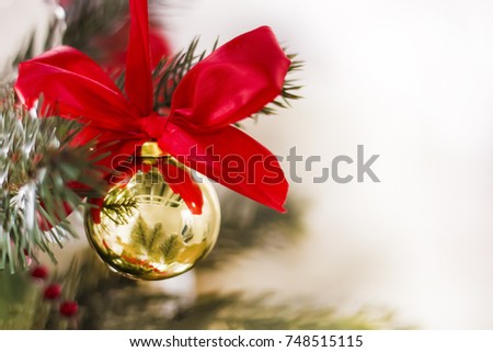 Christmas-tree decorations. Bright beautiful background. Red bow and gold ball. Soft focus. Copy space.