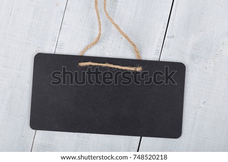 Black notice board with copy space on white wooden background