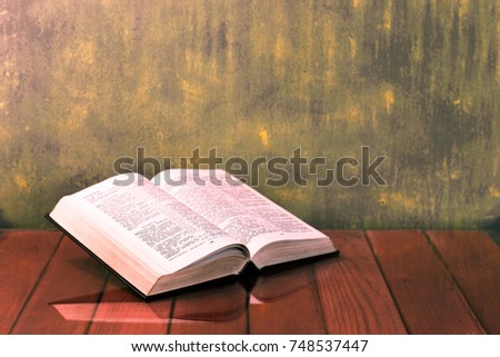 Bible on a wooden red table. Beautiful gold background.Religion concept.