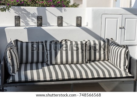 Beautiful relax terrace with gray white striped sofa, Santorini, Greece