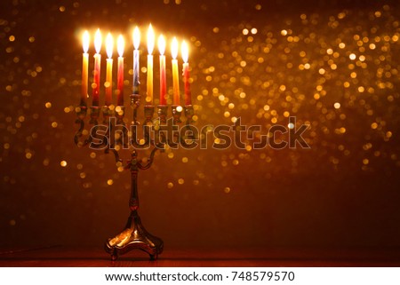 low key image of jewish holiday Hanukkah background with menorah (traditional candelabra) and burning candles
