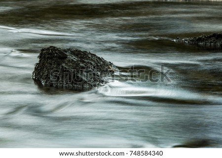 rock in blurred flowing water