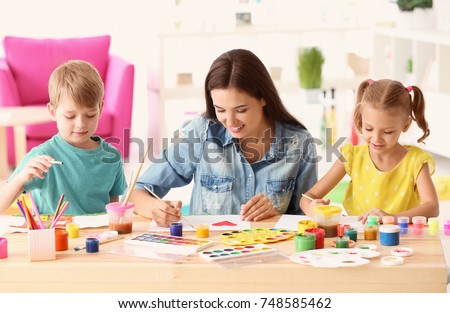 Happy family painting pictures at table indoors