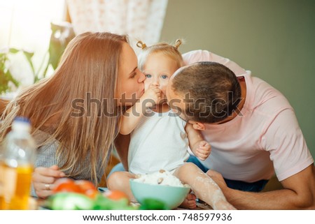 happy Parents giving their daughter a kiss.
