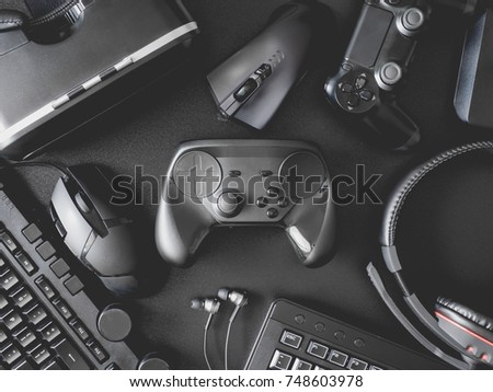top view of gamer concept with gaming gear, mouse, keyboard, joysticks, headset, VR Headset on black table background